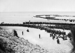 Gemeinfreies Bild: „Dunkirk 26-29 May 1940. British troops line up on the beach at Dunkirk to await evacuation.“